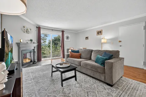 a living room with furniture a flat screen tv and a large window