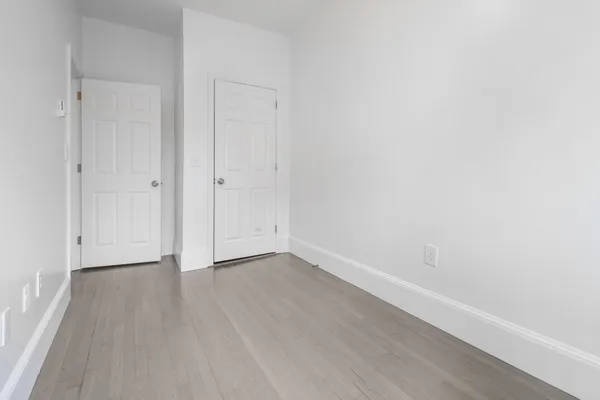 a view of an empty room with wooden floor