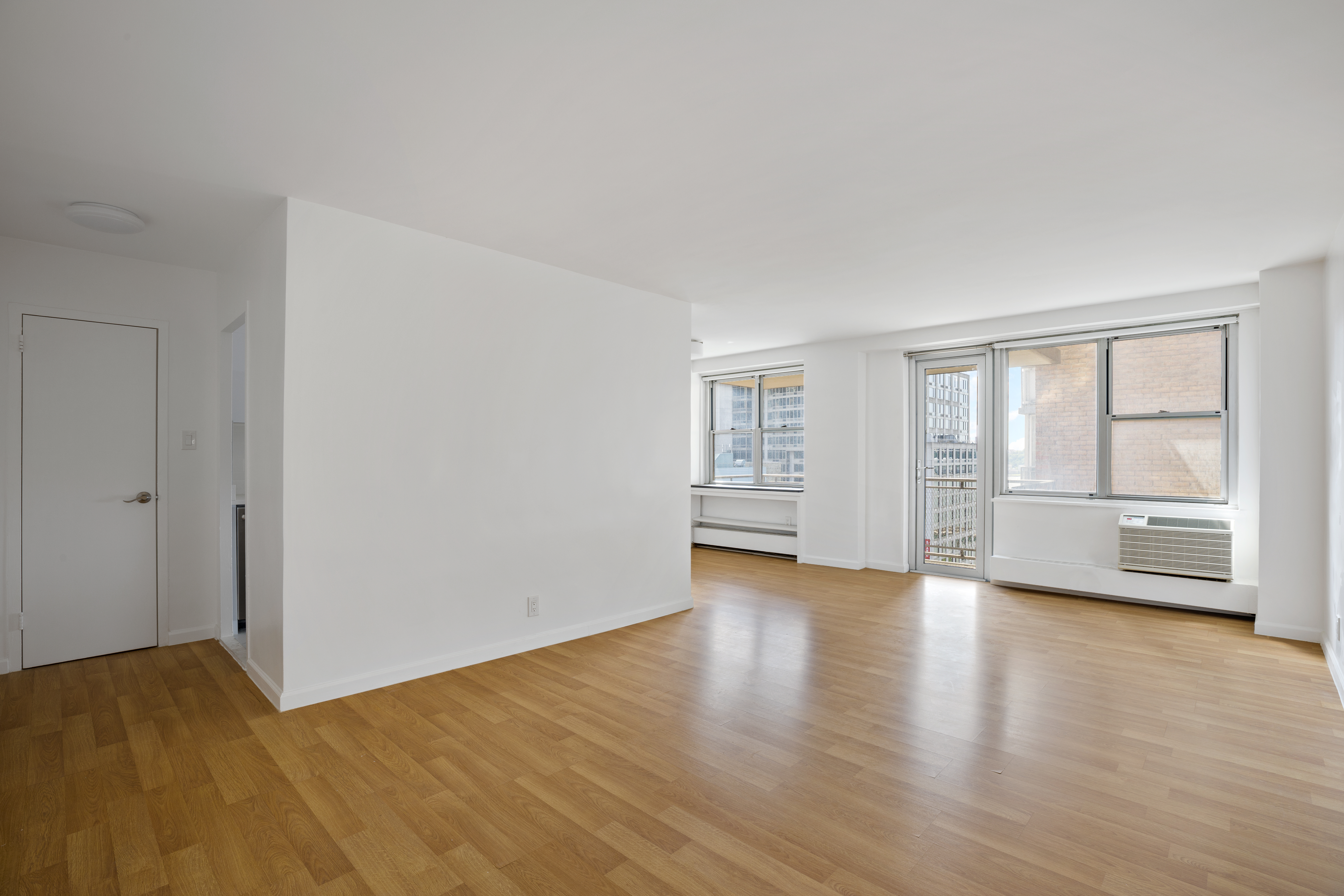 303 West 66th Street, Unit 15DE Manhattan, NY 10023 - Photo 6 of 9 a view of an empty room with a window and wooden floor