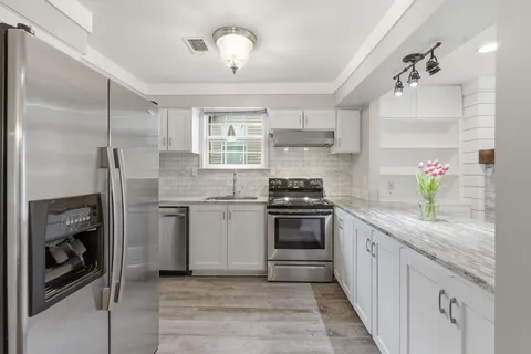 a kitchen with stainless steel appliances granite countertop a refrigerator and a sink