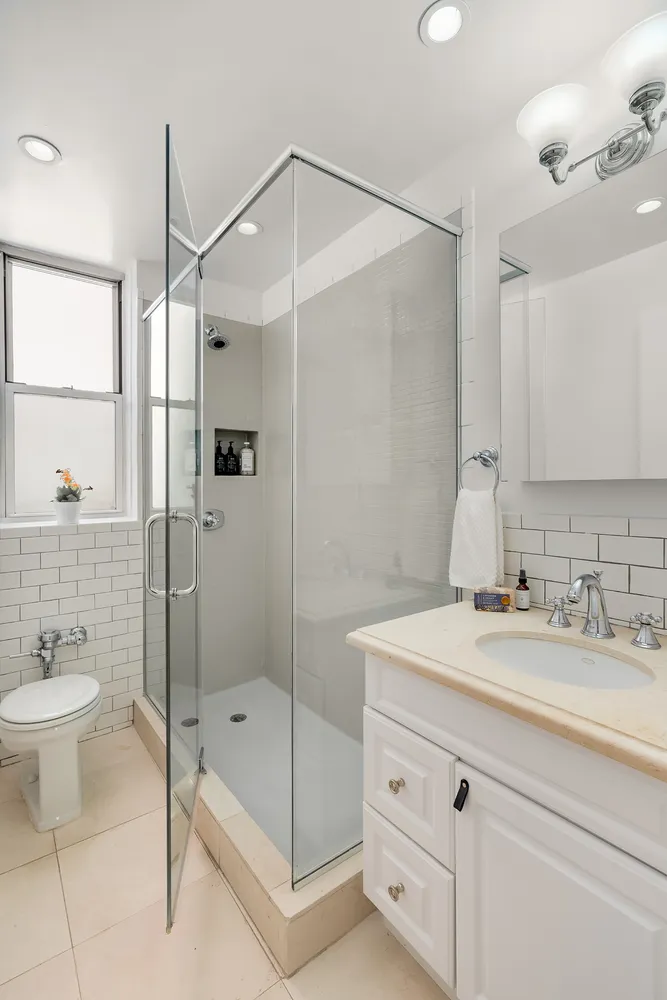 a bathroom with a shower sink and mirror