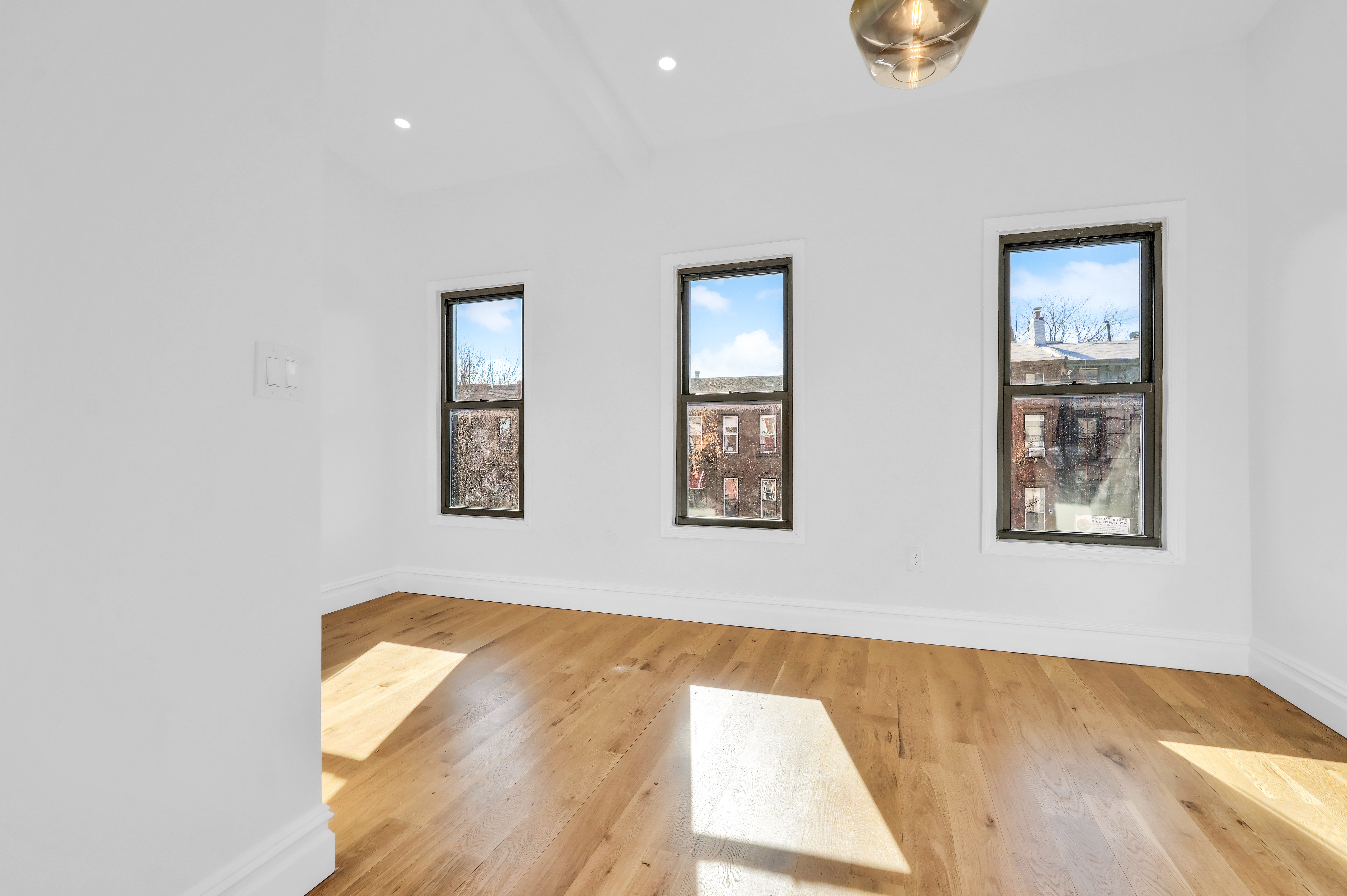 473 Monroe Street Brooklyn, NY 11221 - Photo 22 of 40 a view of a room with wooden floor and window
