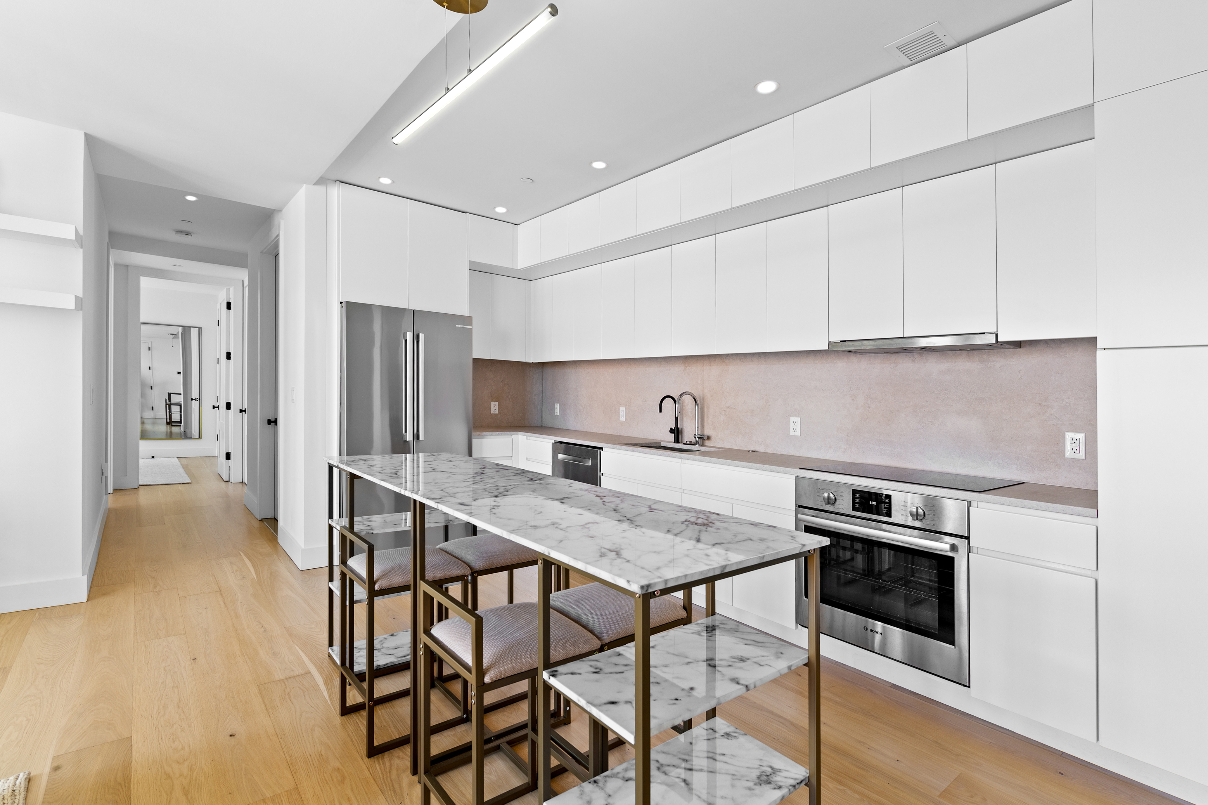 112 Fleet Place, Unit 12A Brooklyn, NY 11201 - Photo 3 of 15 a kitchen with a table chairs refrigerator and cabinets