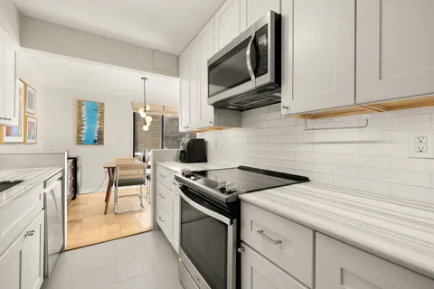 a kitchen with stainless steel appliances granite countertop a refrigerator and a sink