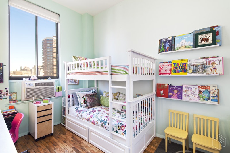 310 East 23rd Street, Unit 11FG Manhattan, NY 10010 - Photo 5 of 9 a bedroom with furniture and a book shelf