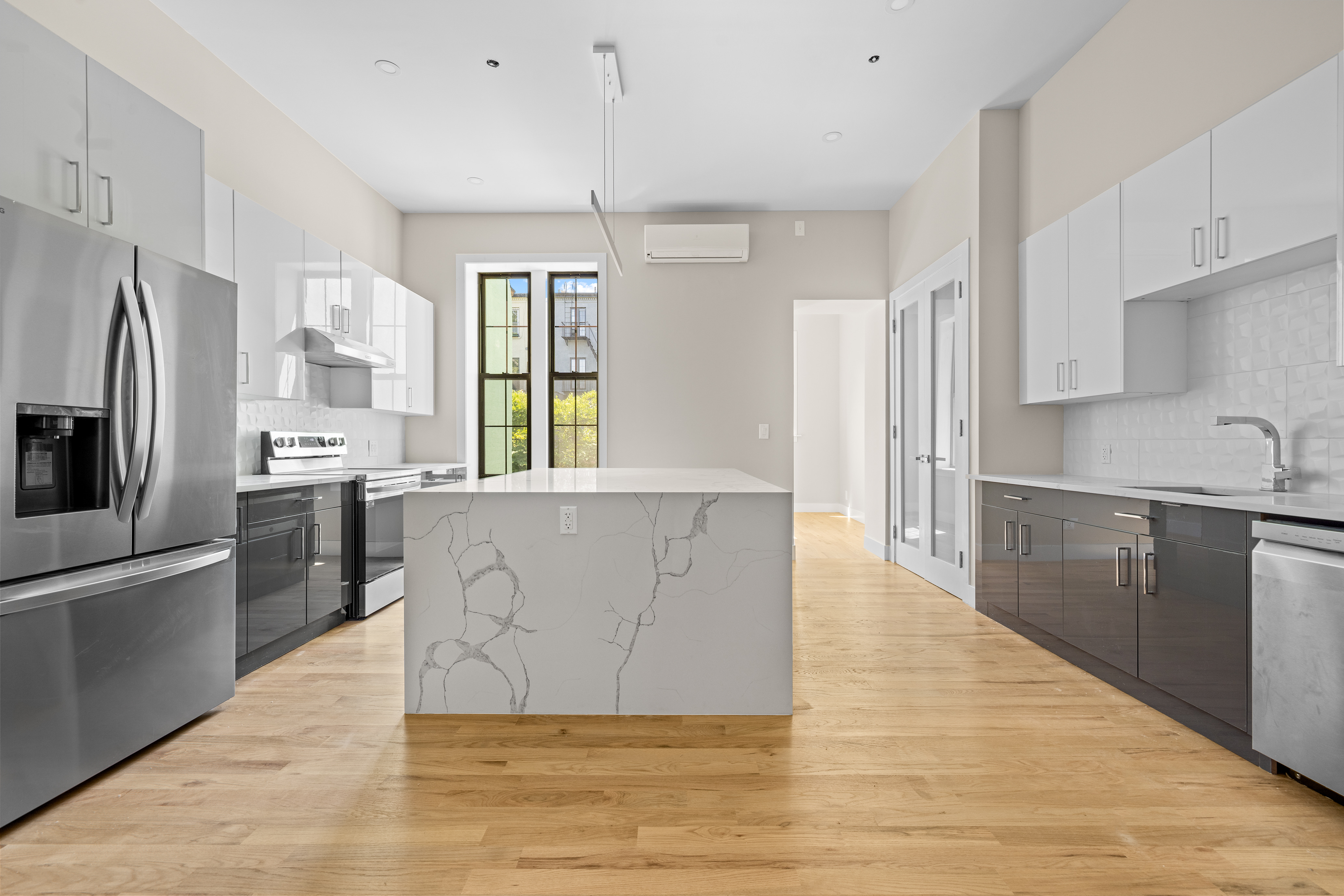 456 Willoughby Avenue, Unit 1 Brooklyn, NY 11206 - Photo 4 of 14 a large kitchen with stainless steel appliances granite countertop a refrigerator a sink dishwasher a oven with white cabinets and wooden floor