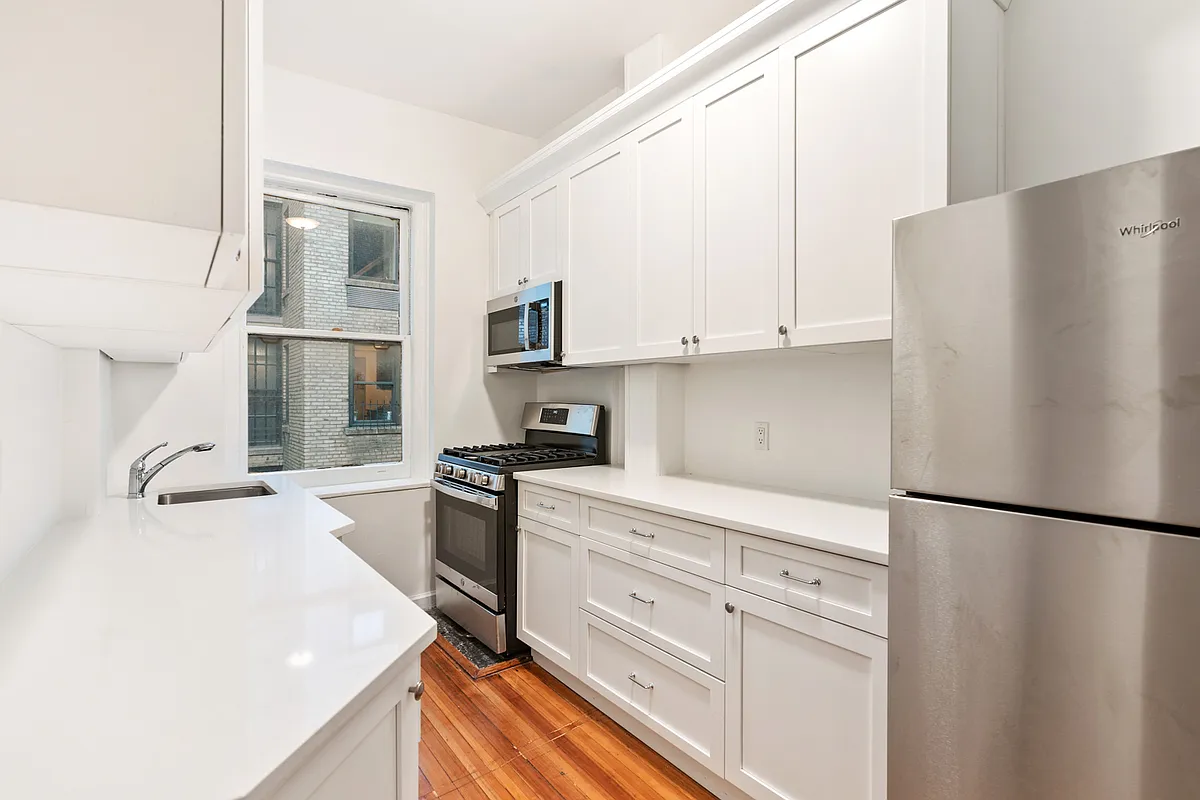 50 East 96th Street, Unit 6D Manhattan, NY 10128 - Photo 2 of 7 a kitchen with stainless steel appliances a refrigerator sink and cabinets