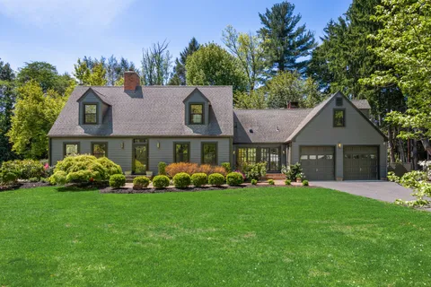 a front view of a house with a garden and plants
