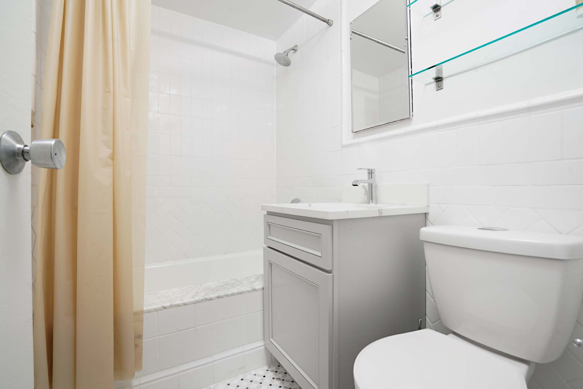 301 East 75th Street, Unit 2G Manhattan, NY 10021 - Photo 7 of 14 a bathroom with a sink toilet and shower