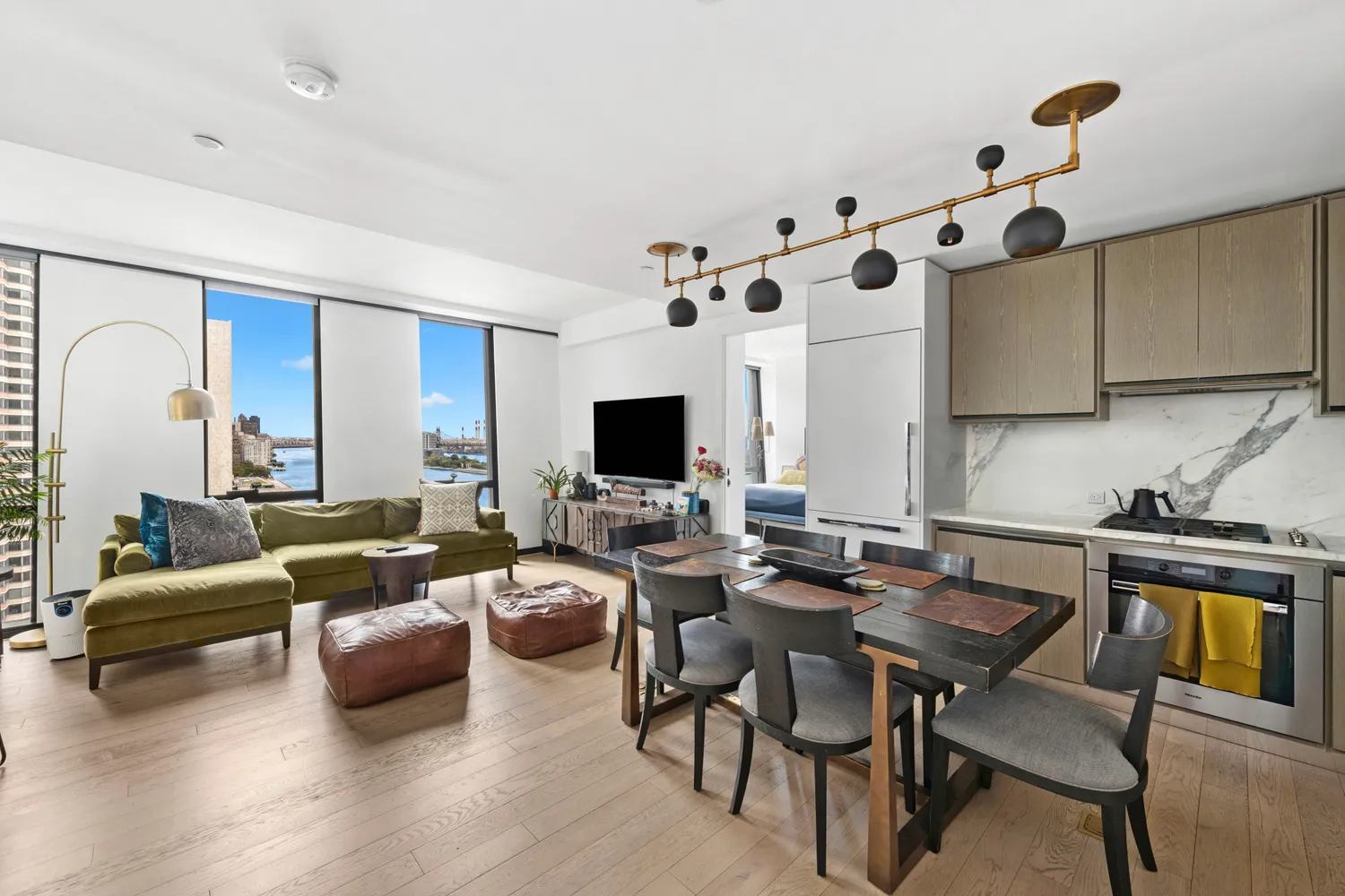 a living room with furniture kitchen view and a flat screen tv