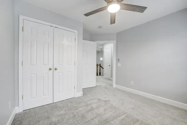 wooden floor in an empty room with a chandelier fan