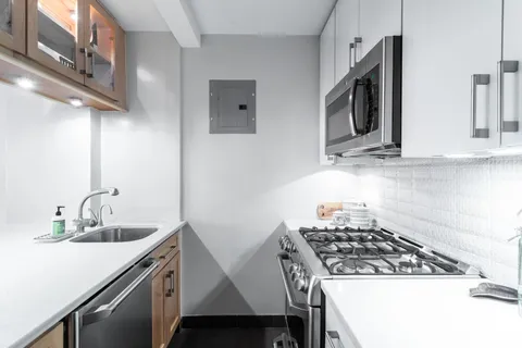 a kitchen with stainless steel appliances a sink a stove and cabinets
