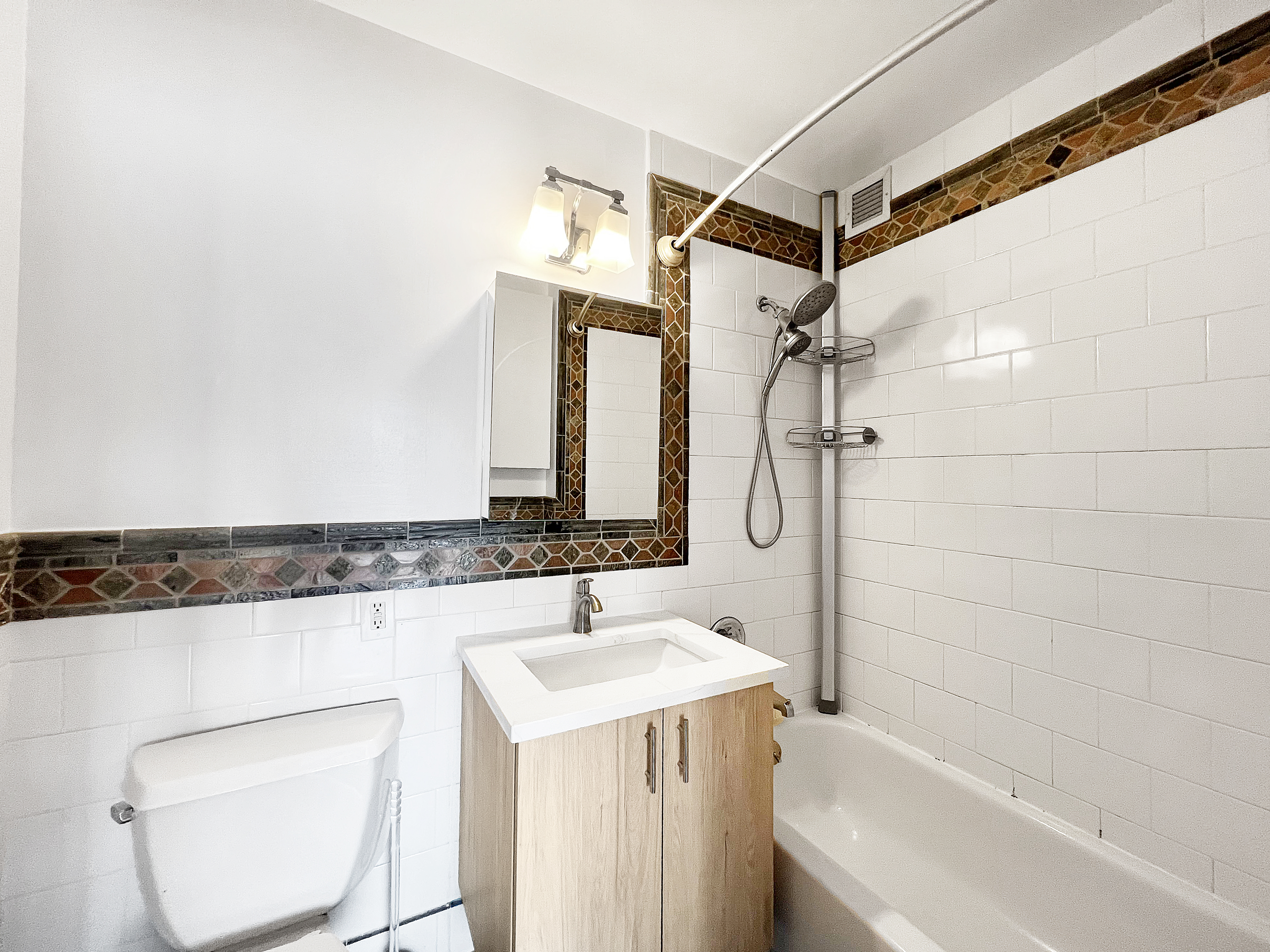 30-85 Vernon Boulevard, Unit 3M Queens, NY 11102 - Photo 6 of 8 a bathroom with a granite countertop sink a toilet and shower