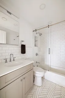 a bathroom with a sink toilet a mirror and shower