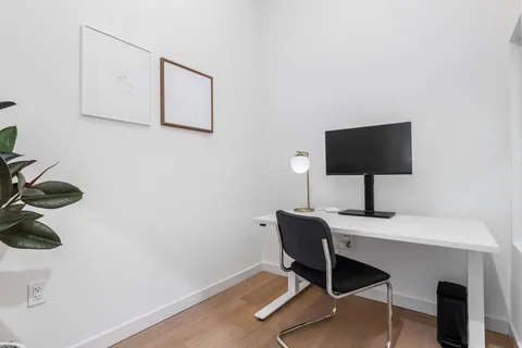 a view of workspace with a computer on a desk and chair