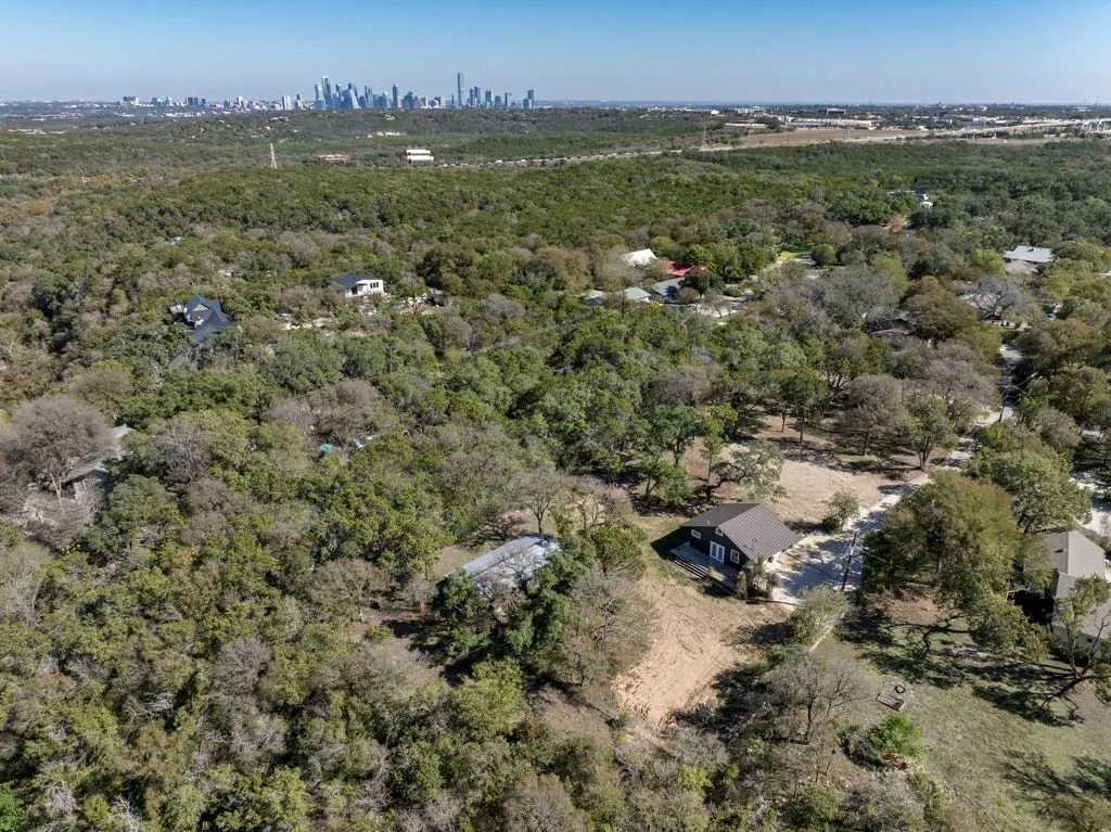 an aerial view of residential houses with outdoor space and trees