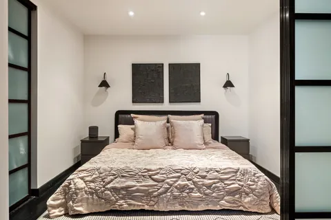 a large bed sitting in a bedroom next to a window