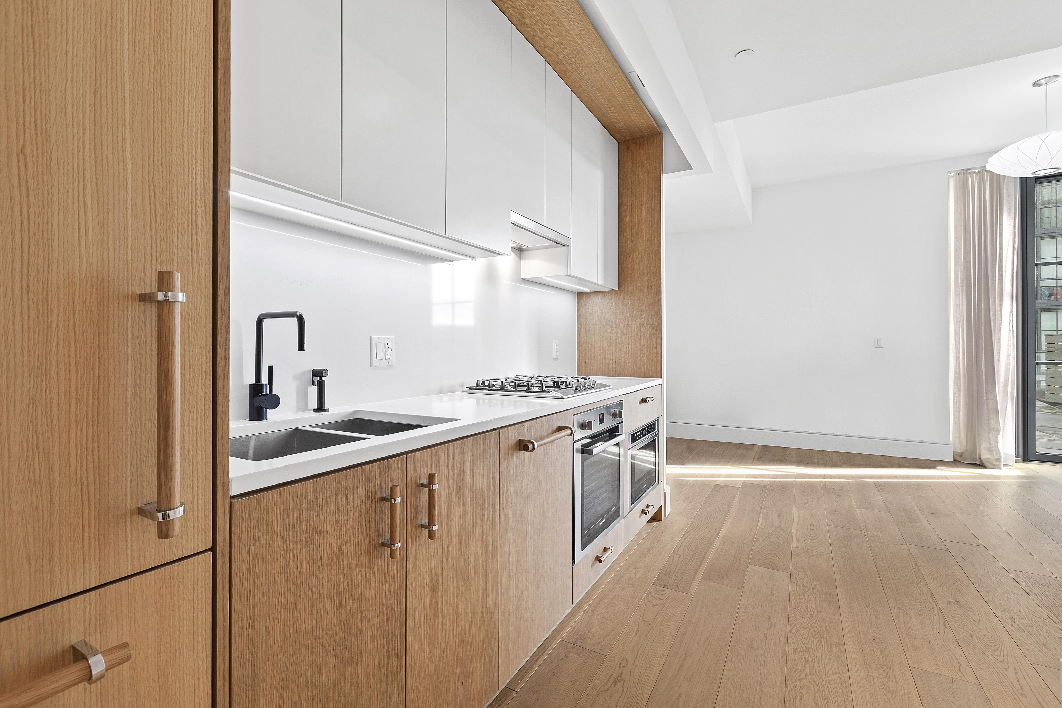 22-18 Jackson Avenue, Unit 209 Queens, NY 11101 - Photo 3 of 14 a kitchen with a sink stove and cabinets