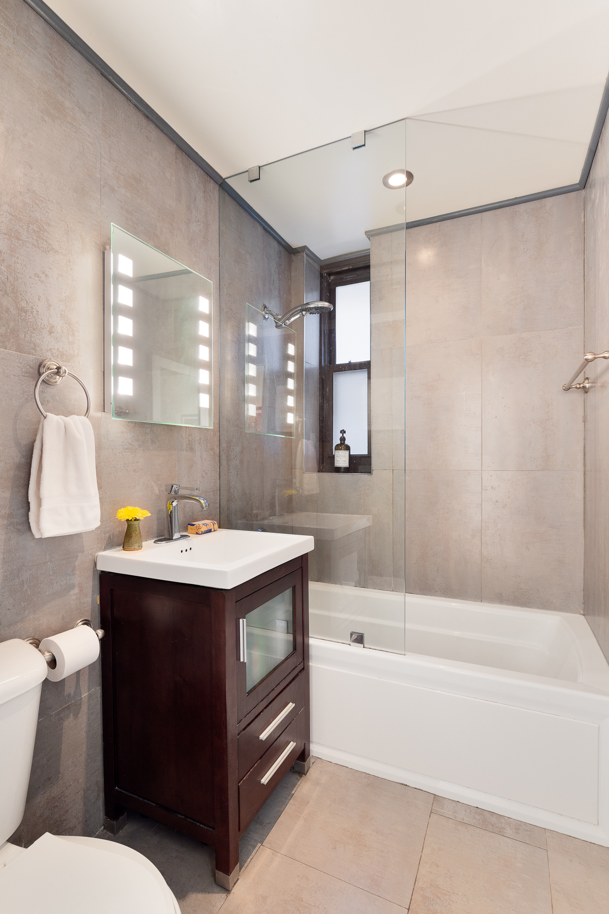 115 Charles Street, Unit 11 Manhattan, NY 10014 - Photo 5 of 7 a bathroom with a sink toilet vanity and bathtub