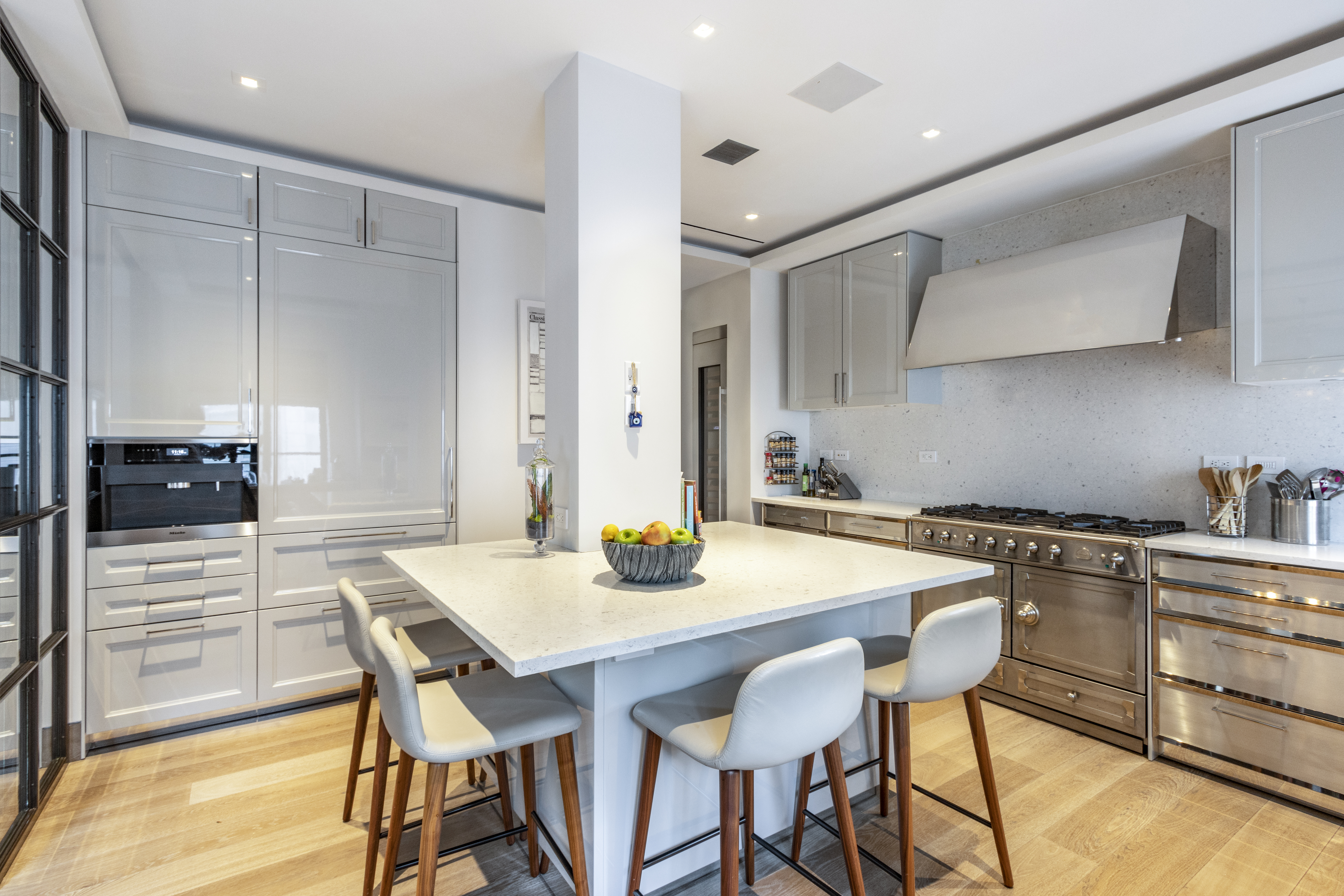 40 East 61st Street, Unit 18A Manhattan, NY 10065 - Photo 4 of 15 a kitchen with a table chairs and a stove
