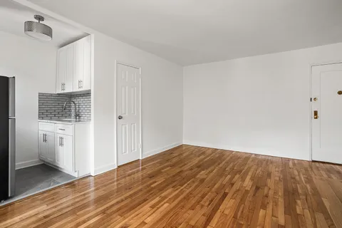 a view of a room with wooden floor and white walls