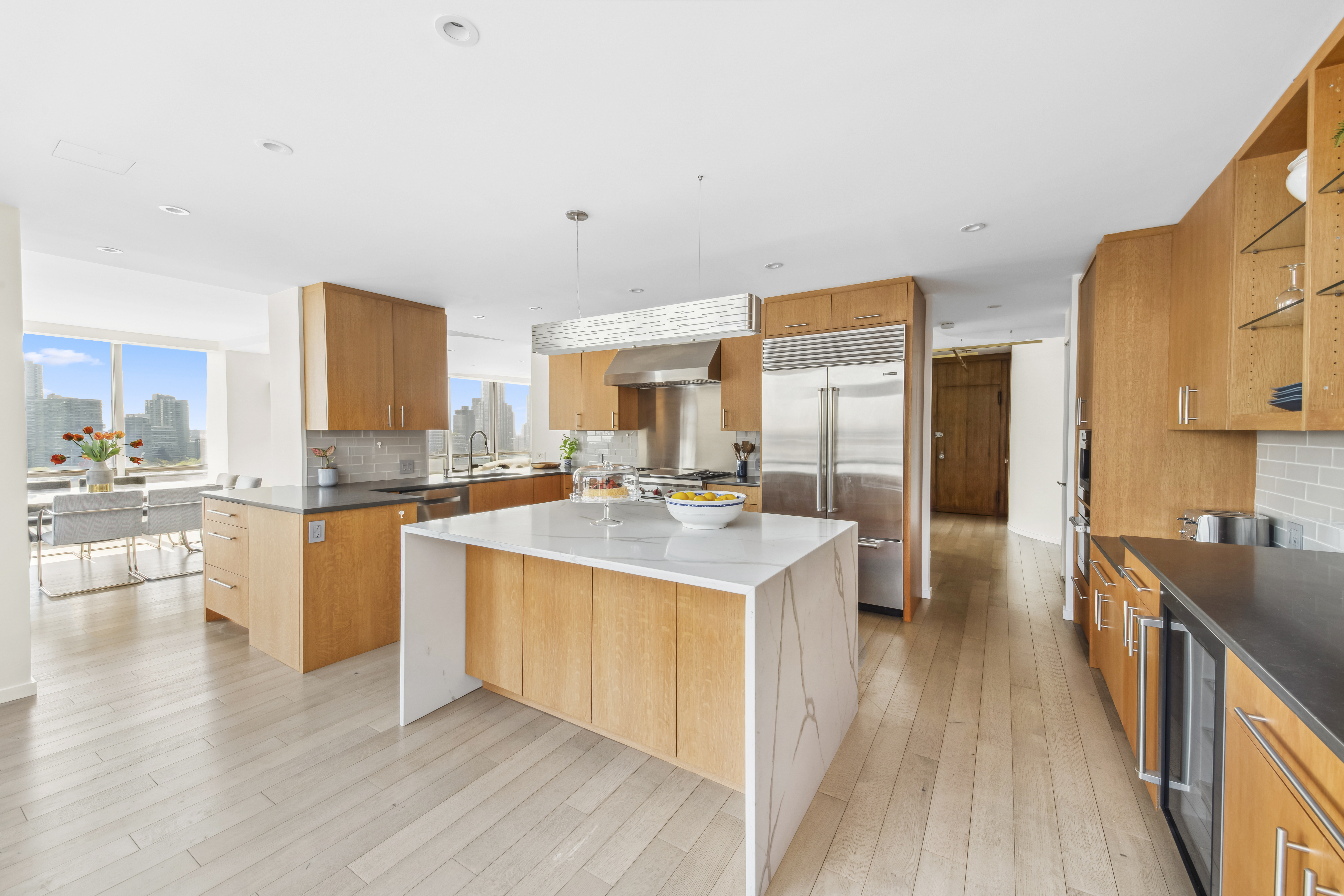 870 United Nations Plaza, Unit 15E Manhattan, NY 10017 - Photo 13 of 19 a large kitchen with a lot of counter space and wooden floor