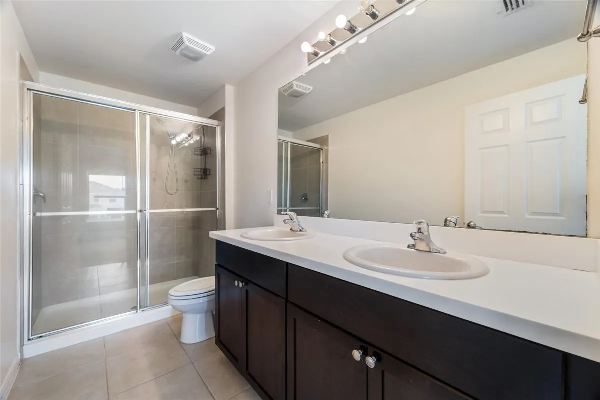 a bathroom with a double vanity sink mirror and toilet
