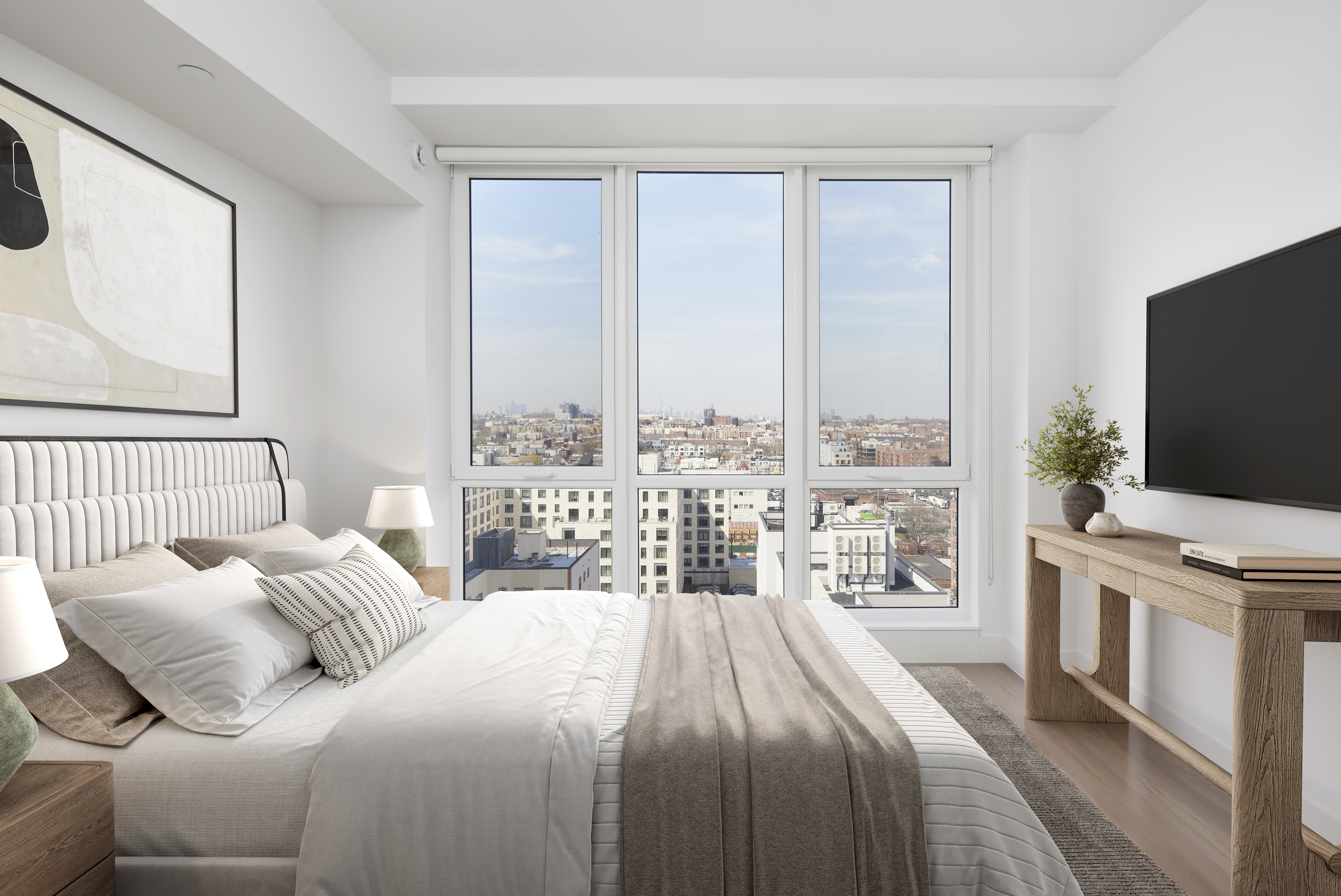 a bedroom with a large bed and a flat tv screen on dresser