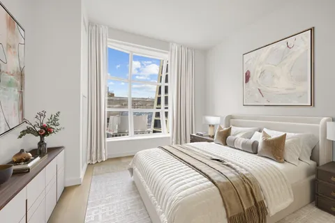 a bedroom with a bed and a large window