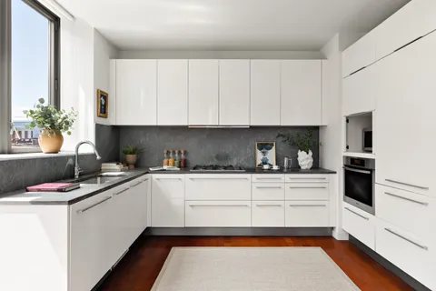 a kitchen with granite countertop a sink stainless steel appliances and cabinets