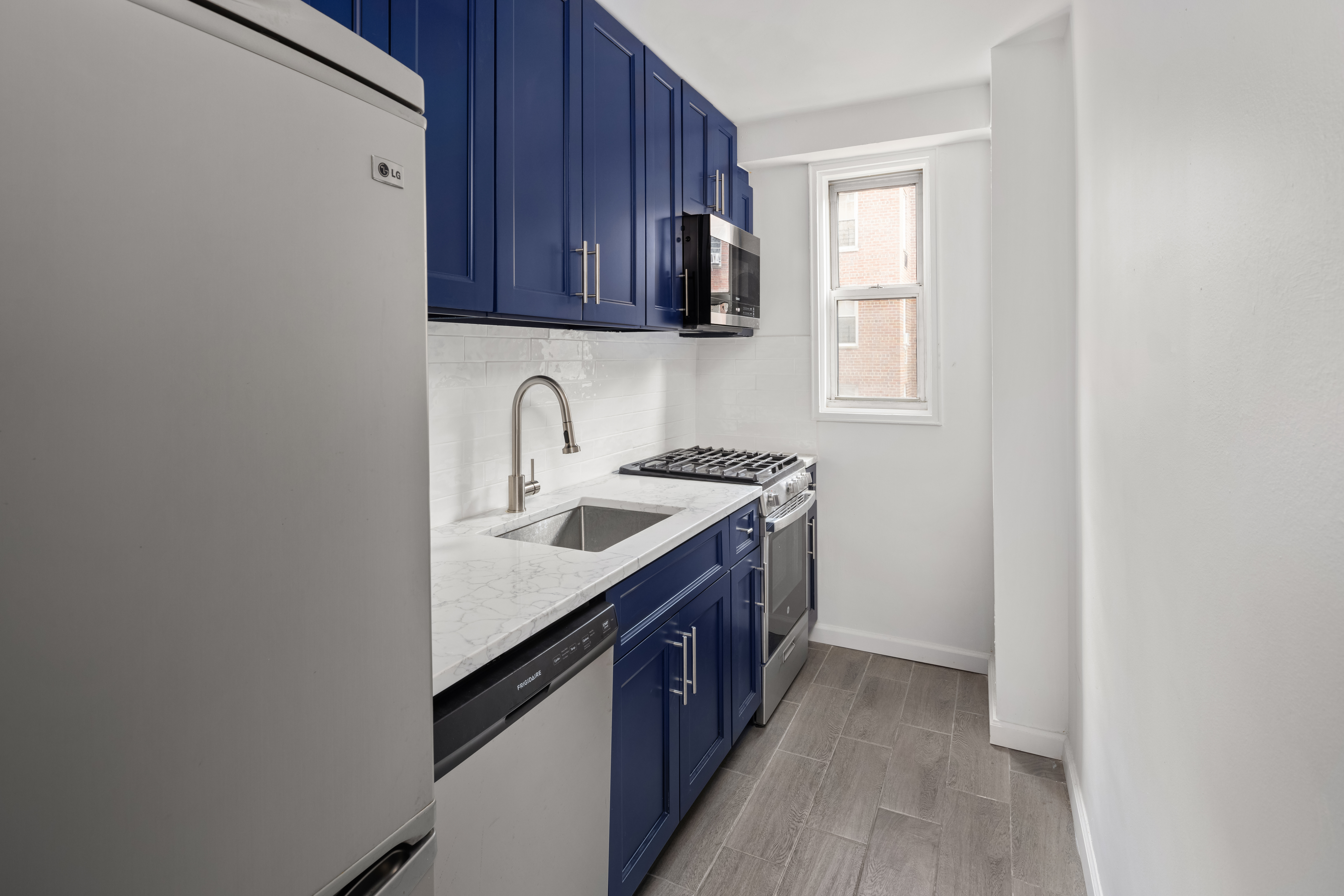 110-50 71st Road, Unit 5N Queens, NY 11375 - Photo 3 of 8 a kitchen with a sink cabinets and a window
