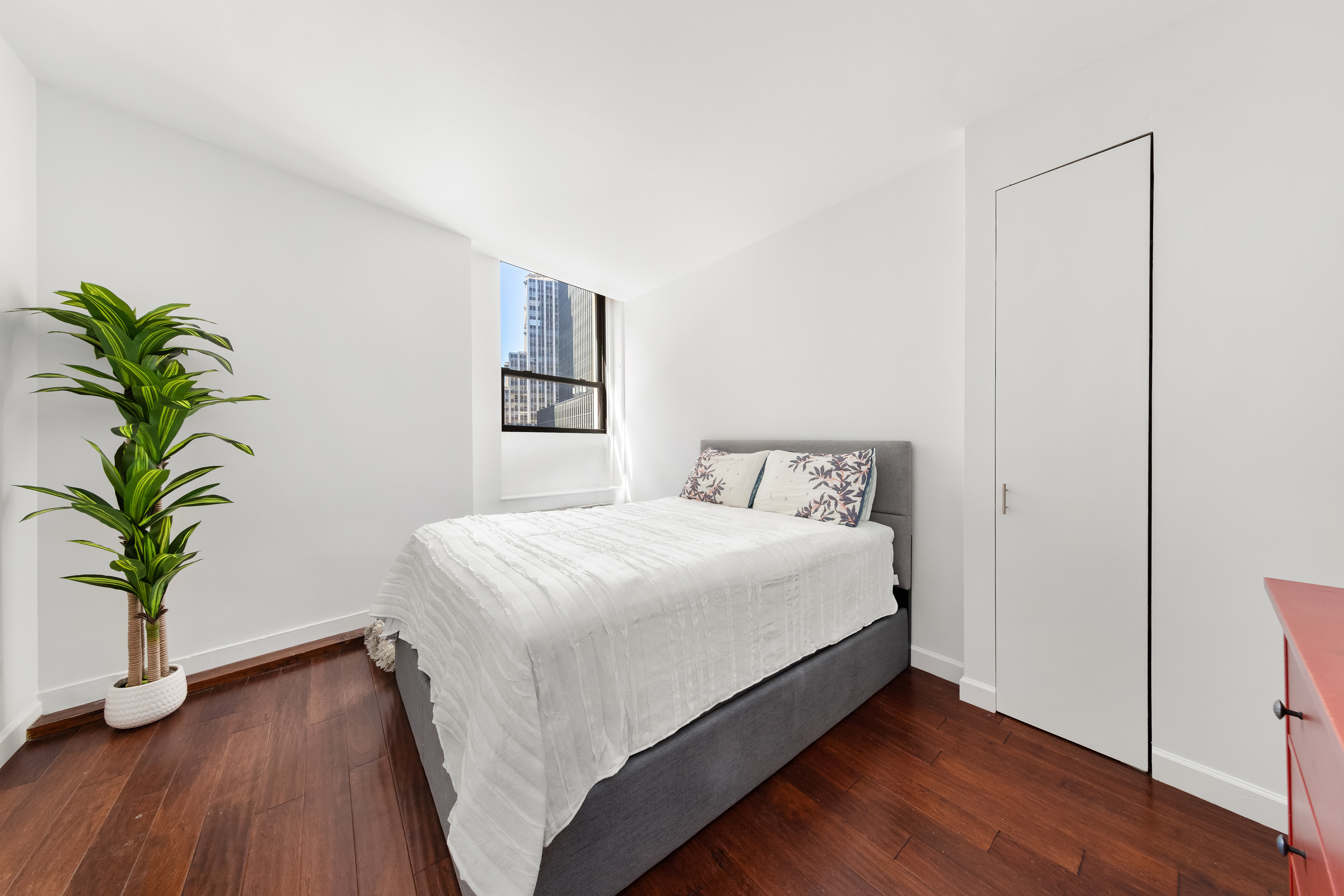 3 Hanover Square, Unit 8E Manhattan, NY 10004 - Photo 4 of 7 a bedroom with a bed and a potted plant