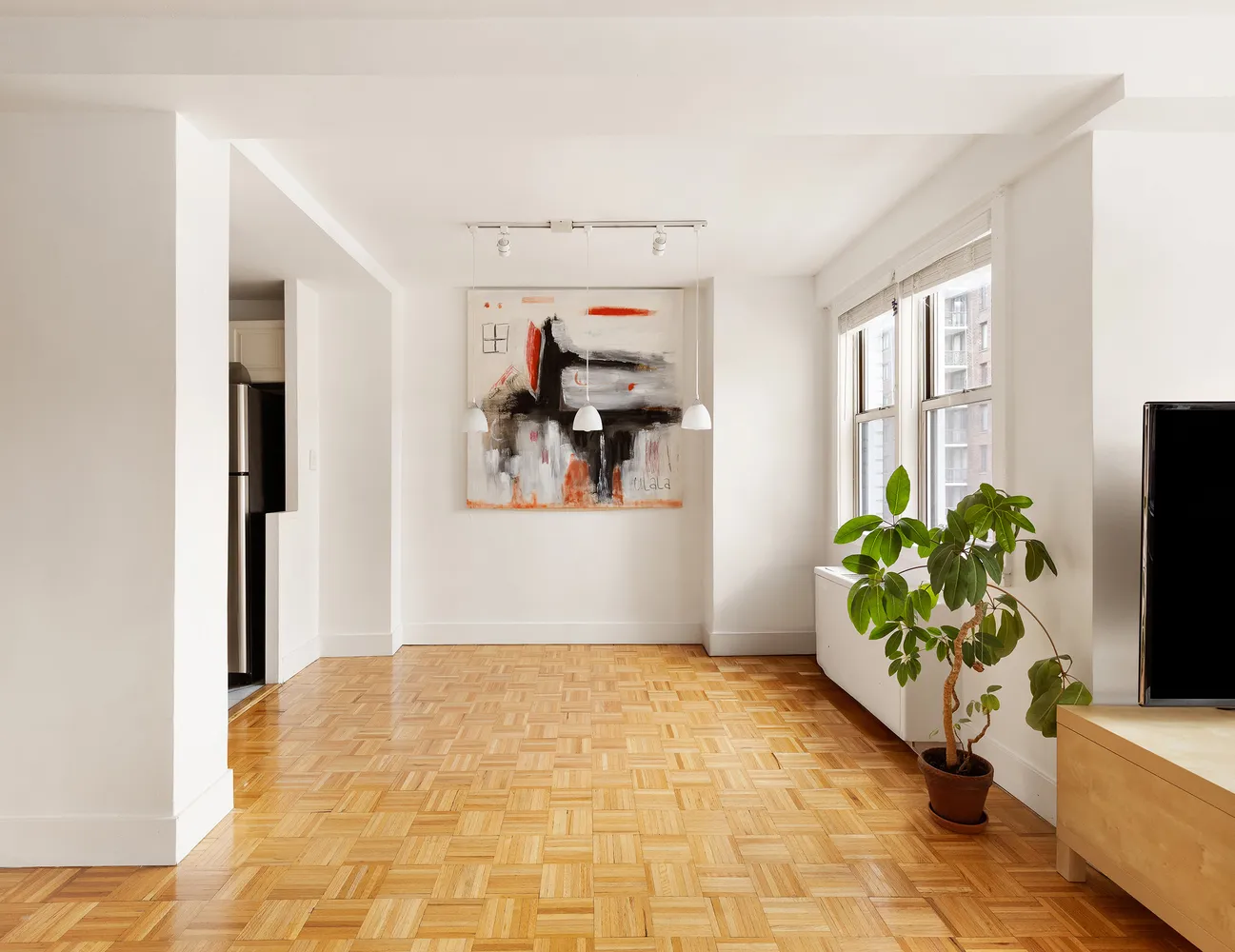 a view of a livingroom with wooden floor and a flat screen tv
