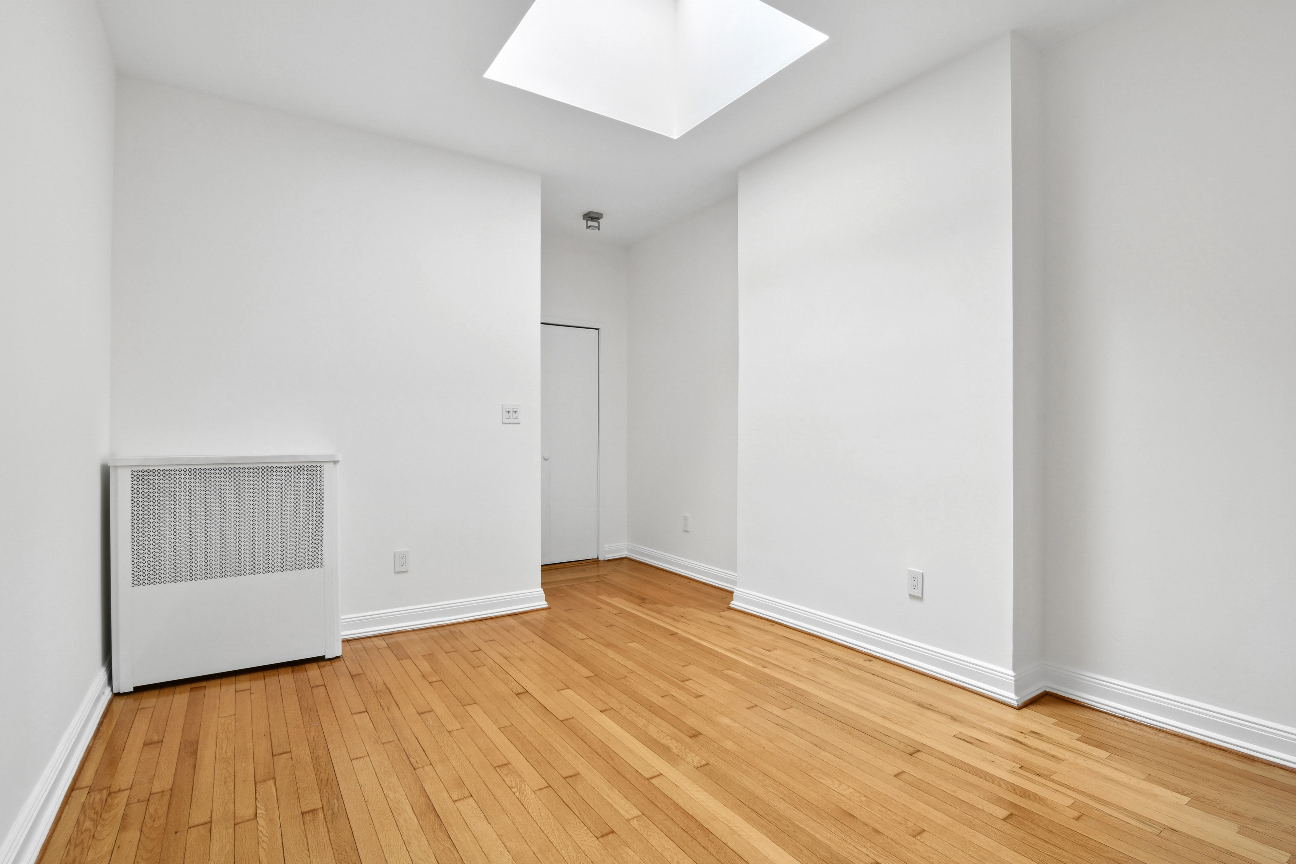 109 East 38th Street, Unit 3A Manhattan, NY 10016 - Photo 6 of 13 an empty room with wooden floor and closet