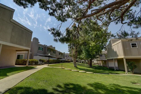 a view of a house with a big yard and large trees