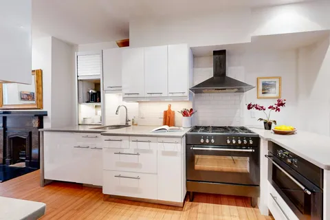 a kitchen with granite countertop a stove and a wooden floors