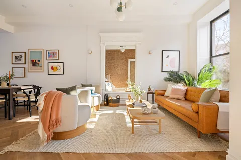a living room with furniture potted plant and a window