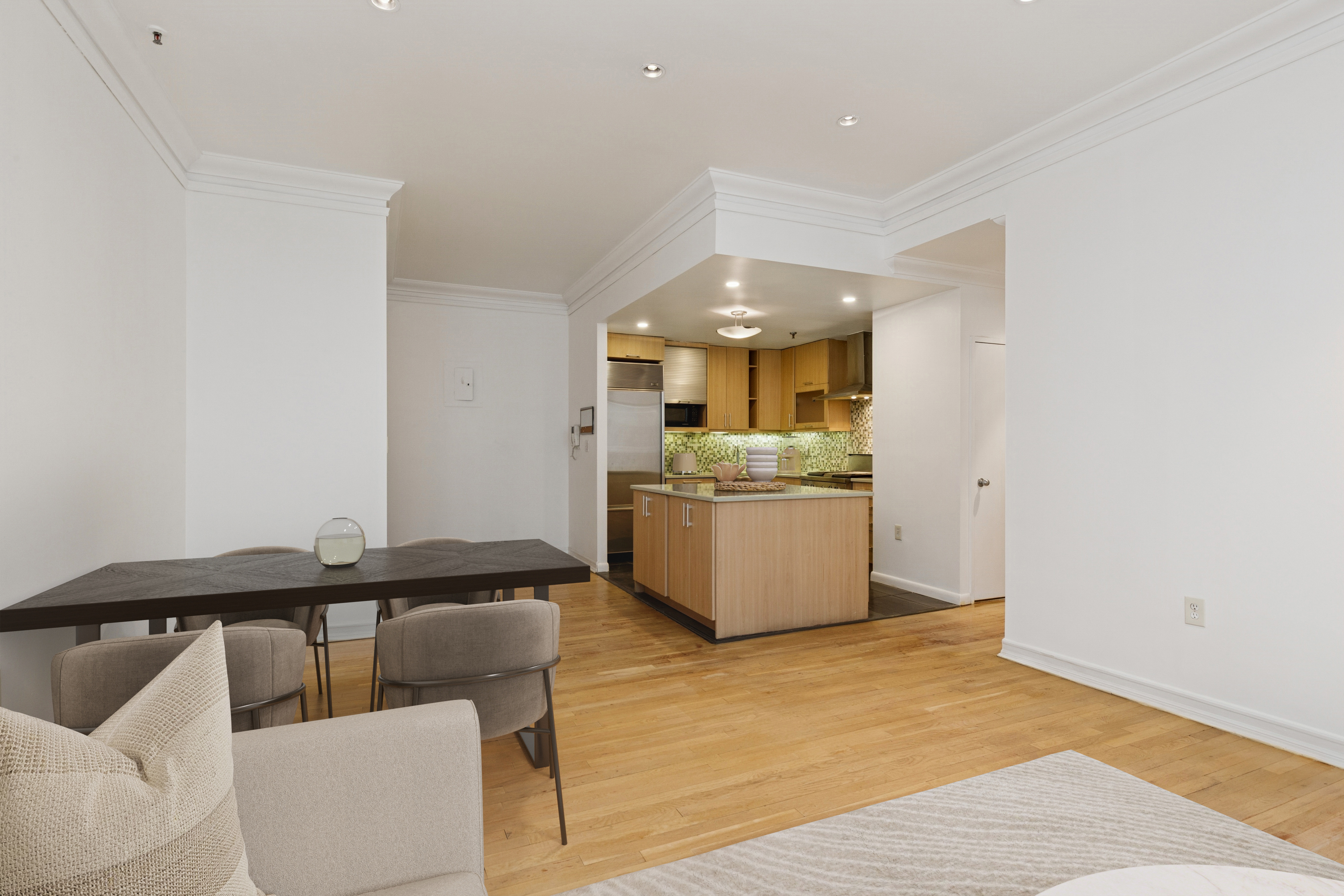 136-140 West 23rd Street, Unit 4CC Manhattan, NY 10011 - Photo 4 of 14 a living room with a couch and a view of kitchen