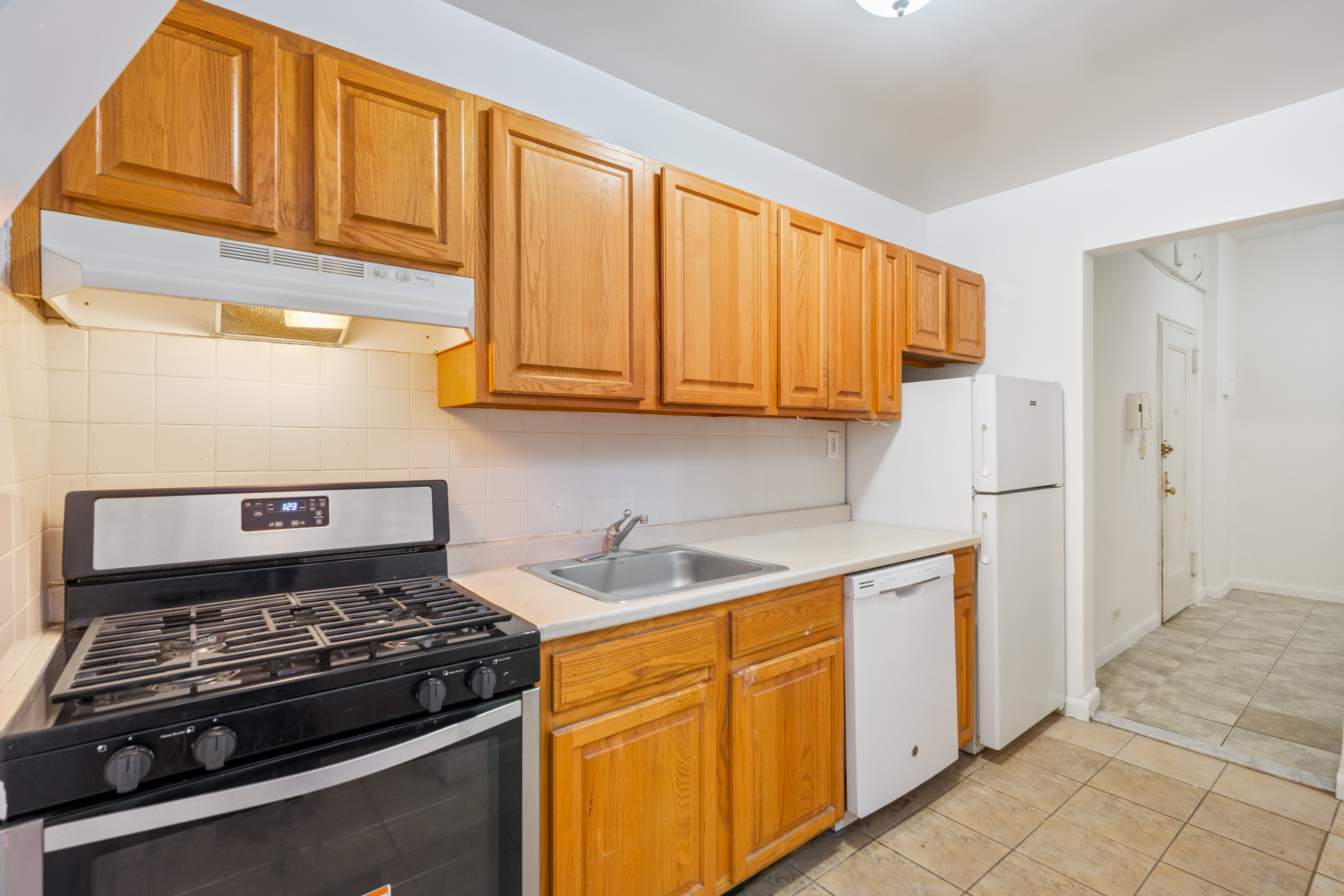 68-63 108th Street, Unit 1B Queens, NY 11375 - Photo 6 of 13 a kitchen with stainless steel appliances granite countertop a stove and a refrigerator