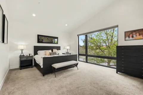 a bedroom with a bed and a dresser next to a window
