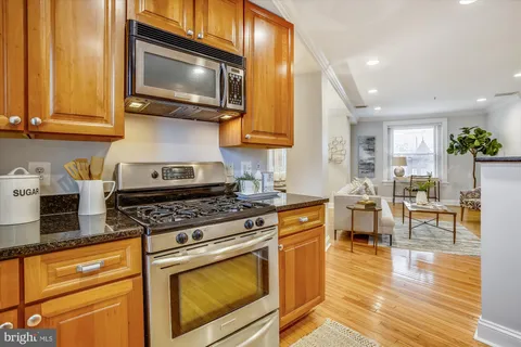 a kitchen with stainless steel appliances granite countertop wooden cabinets a stove top oven a sink and dishwasher