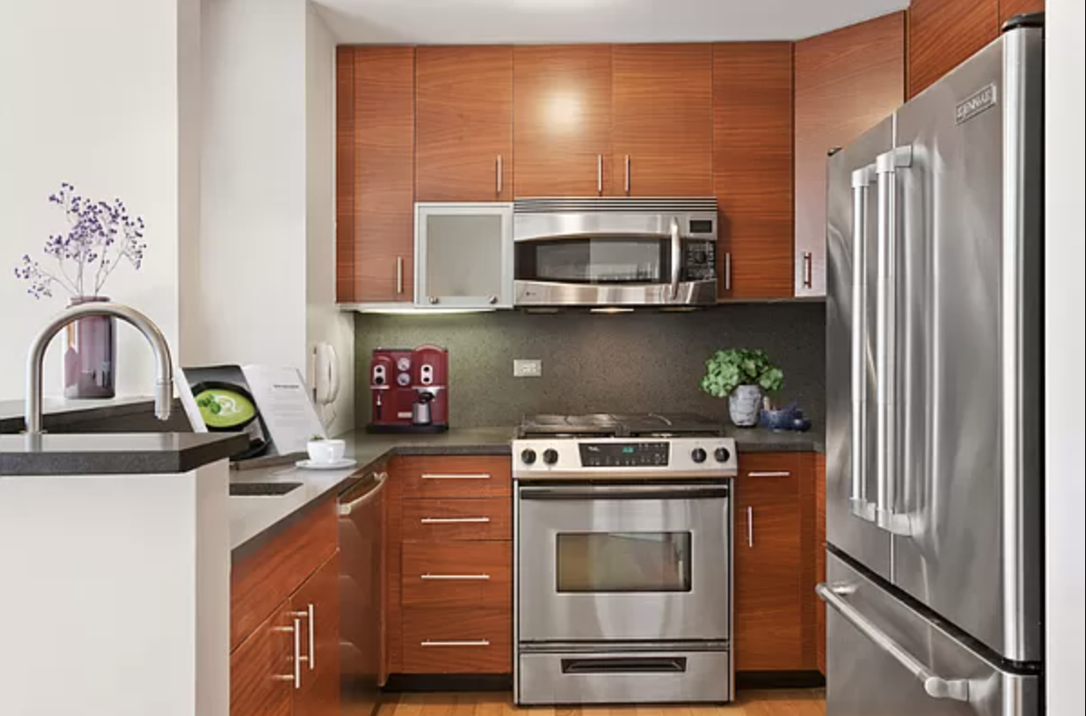 a kitchen with stainless steel appliances granite countertop a stove a microwave and a refrigerator