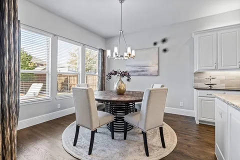 a dining room with furniture a chandelier and wooden floor