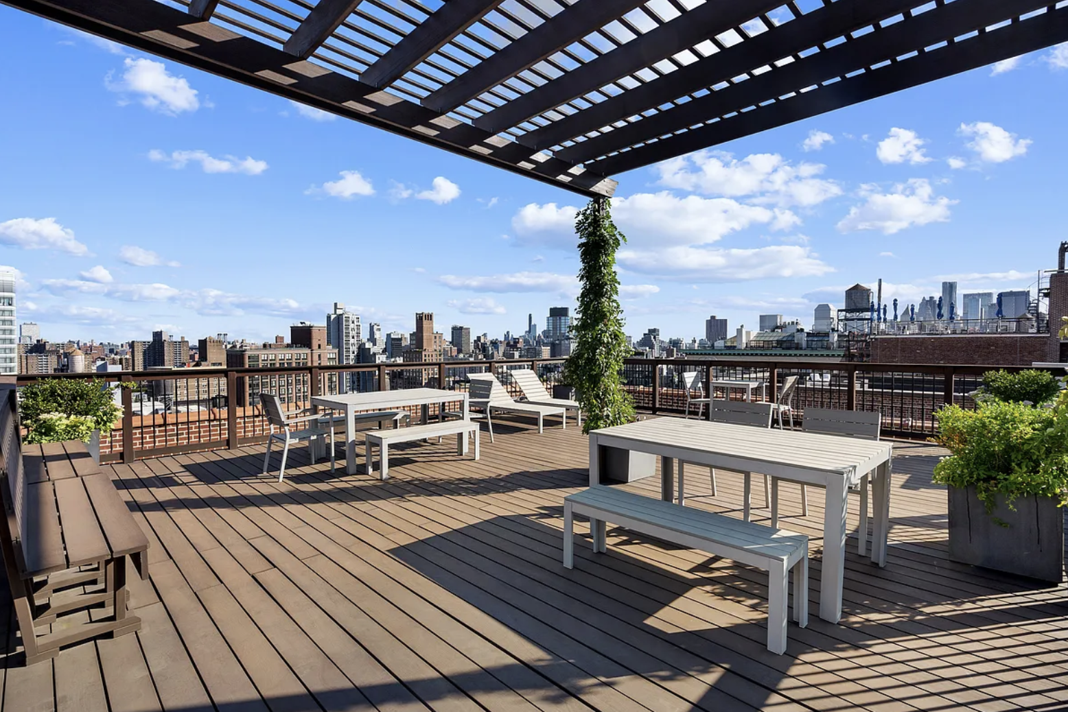 718 Broadway, Unit PHC Manhattan, NY 10003 - Photo 15 of 21 a view of a roof deck with dining table and chairs with wooden floor