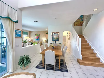 a dining room filled with furniture and a potted plant