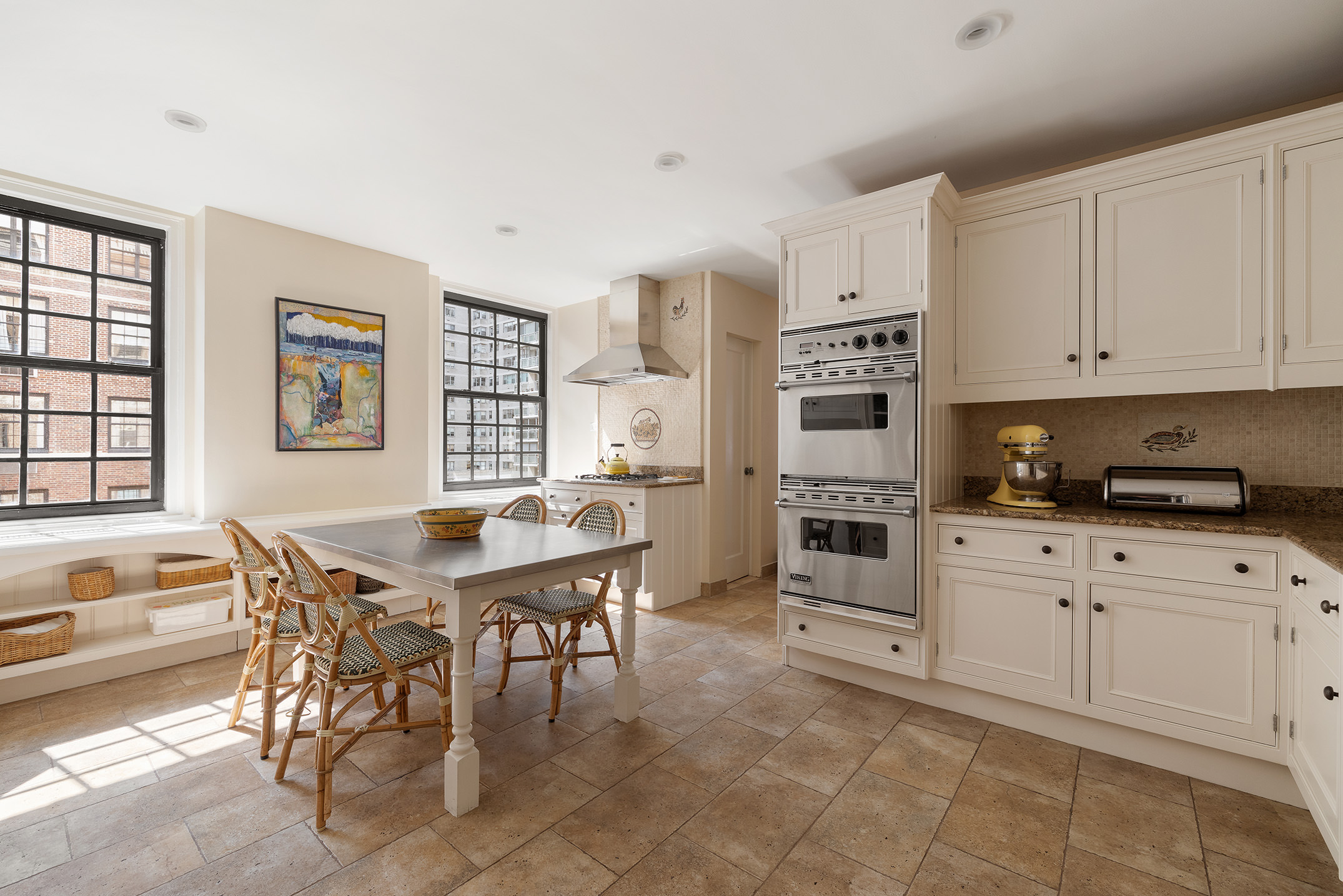 129 East 69th Street, Unit 8/9A Manhattan, NY 10021 - Photo 5 of 16 a kitchen with stainless steel appliances granite countertop a stove and white cabinets
