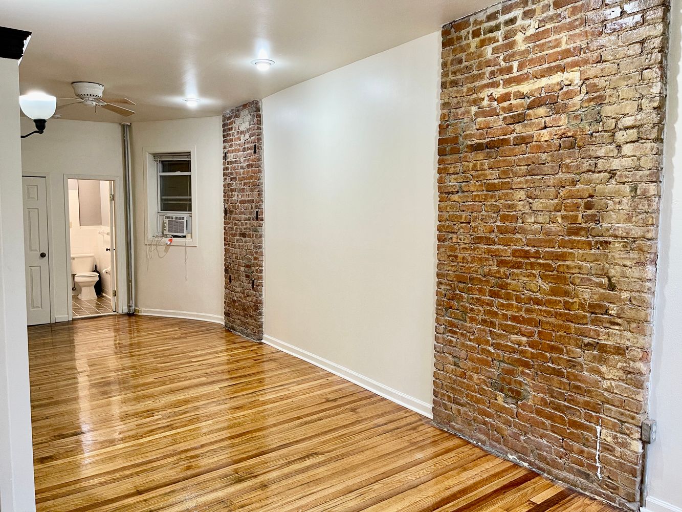 1672 Park Avenue Manhattan, NY 10035 - Photo 24 of 35 a view of a hallway with wooden floor and a bathroom