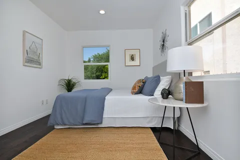 a bedroom with a bed and a painting on the wall