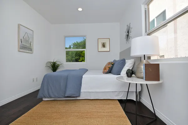 a bedroom with a bed and a painting on the wall