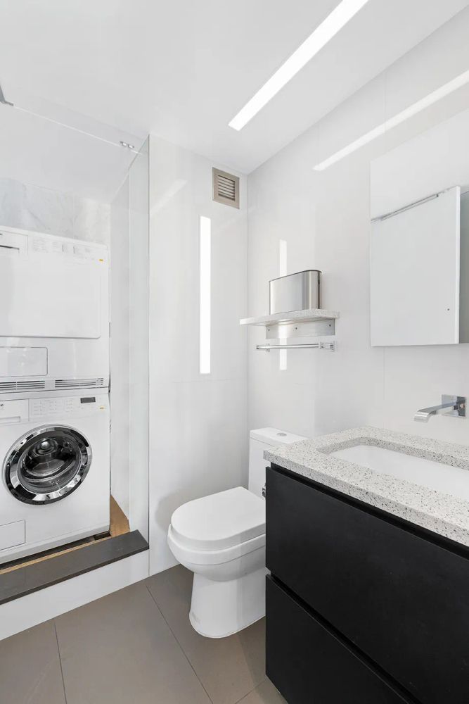 236 East 47th Street, Unit 27DE Manhattan, NY 10017 - Photo 9 of 16 a bathroom with a granite countertop sink a toilet and vanity